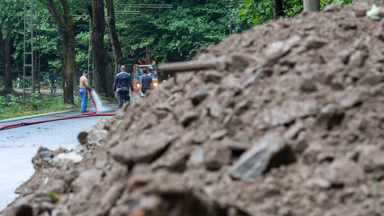 Ein Geröllhaufen durch einen Erdrutsch liegt auf der Straße.
