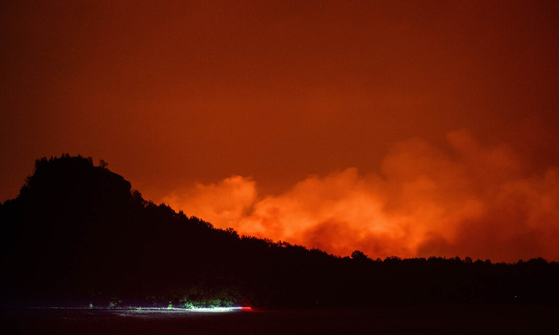 Ein Waldbrand in der Sächsisch-Böhmischen Schweiz bei Nacht.