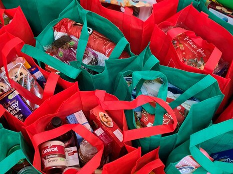Einkaufstaschen in rot und grün mit verschiedenen Inhalten.